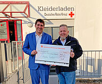 Zwei Männer halten einen symbolischen Spendenscheck