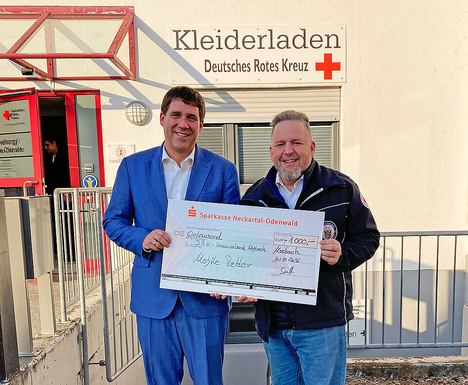 spende_paar_mr.jpg Zwei Männer halten einen symbolischen Spendenscheck