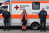 Yasmin El-Bougi (m.) mit ihren Ausbildern Robin Bracht (l.) und Henning Waschitschek (r.) vor einem Einsatzwagen an der Mosbacher DRK-Rettungswache in der Sulzbacher Straße. 