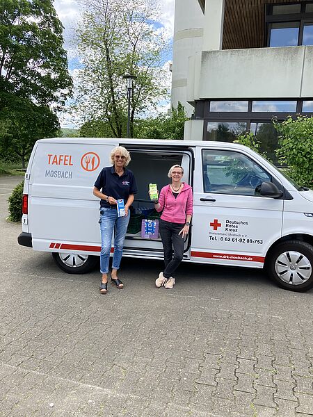 zwei Personen vor dem Fahrzeug des Tafelladenss