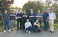 Sieben Personen mit Urkunden und ihre Ausbilder