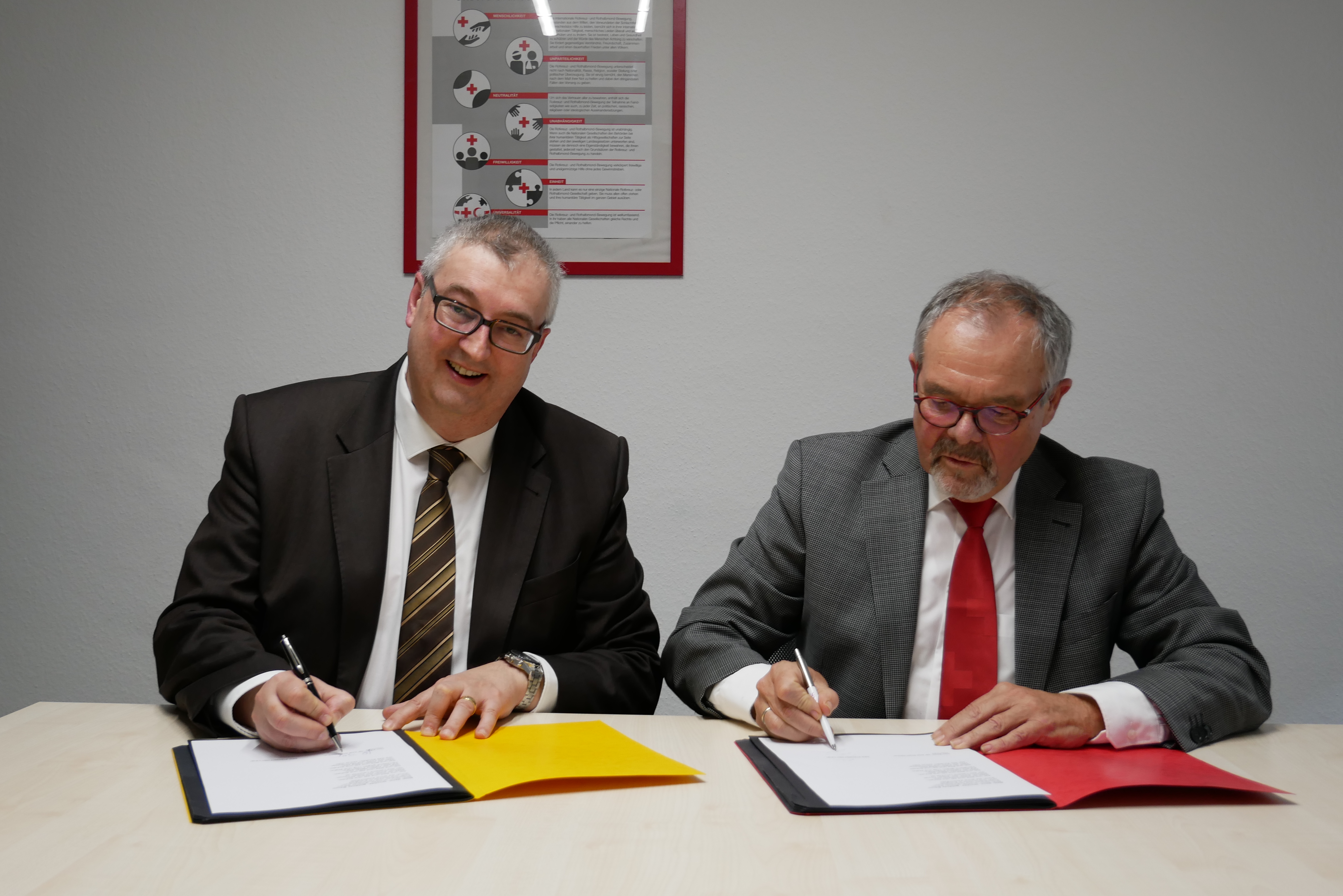 Joachim Bader, Geschäftsführer der AOK Rhein-Neckar-Odenwald (links), und DRK-Präsident Gerhard Lauth unterzeichnen den Kooperationsvertrag „Prävention in der Pflege“. 